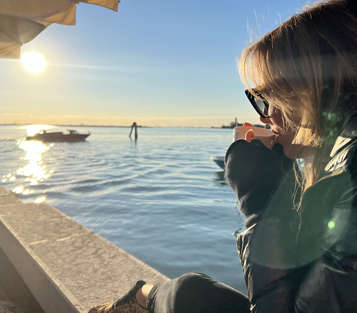 view of water and woman sipping coffee