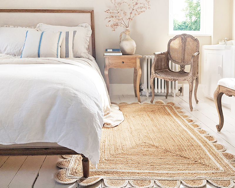 Naturelle linen bed with white bedding and scalloped jute rug