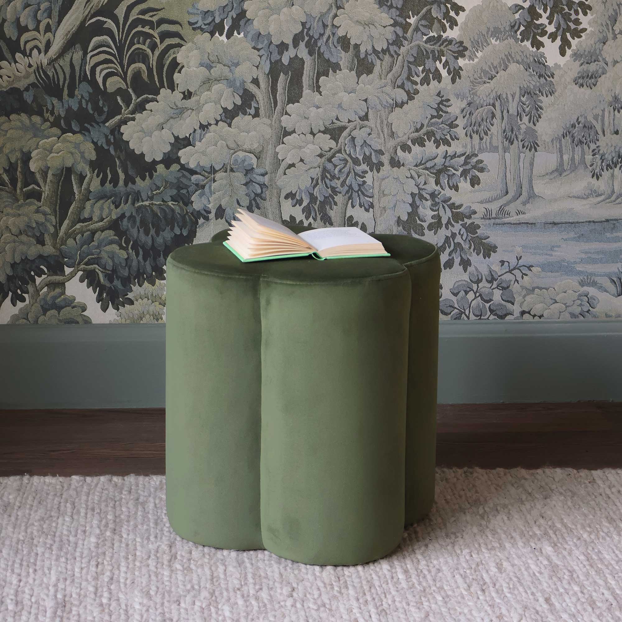 green velvet clover pouffe with book 
