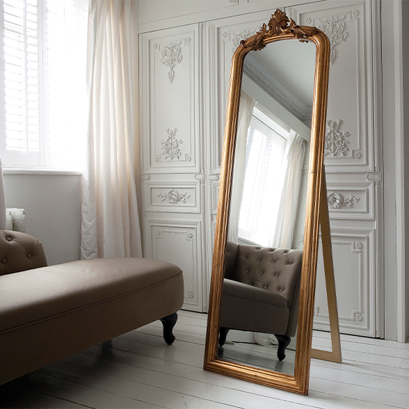 Tall, freestanding mirror, with a gold gilt frame. 